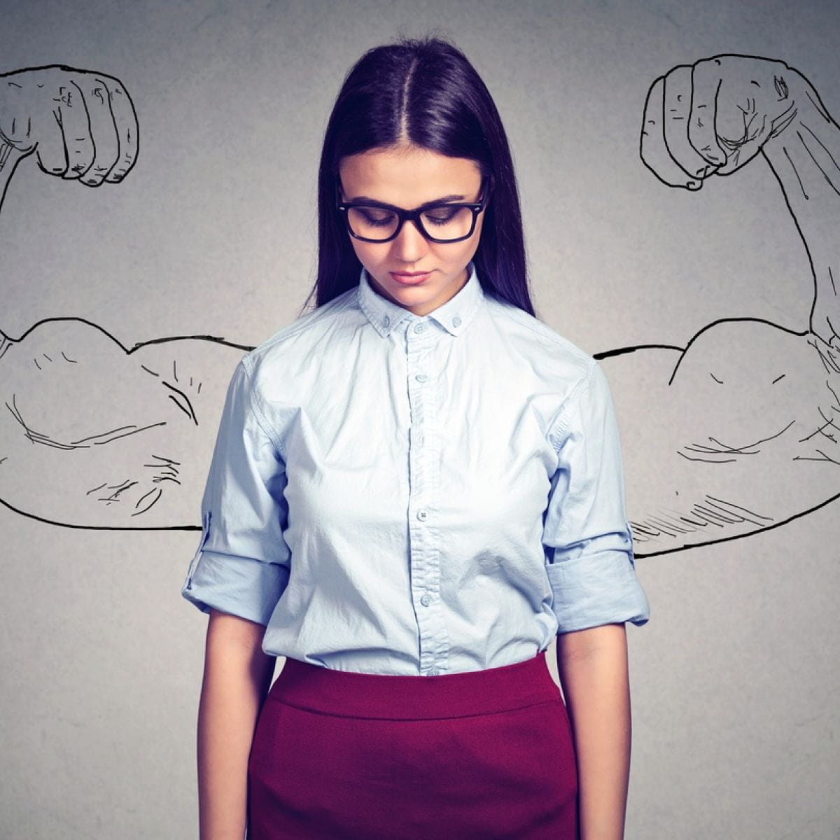 Billede af nedtryk kvinde med påtegnede stærkmandsarme. Kvinder har nul % selvtillid, når det kommer til lønforhandling. Få de tricks, som især får mænd til at gå tilfredse fra lønforhandlingerne 