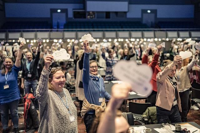 deltagere på midtvejdsmøde holder ønskeskyer i vejret